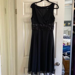 Elegant black dress with satin midsection and a beautiful hemline. Size 12.